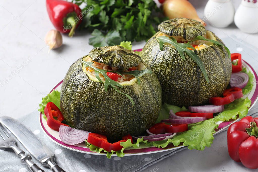 Zucchini stuffed with rice and vegetables on light gray background. Vegetarian food. Close-up.