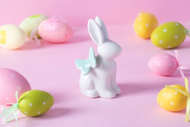 Paskalya tavşanı ve pembe arka planda renkli yumurtalar. Paskalya konsepti. Paskalya tebrik kartı.