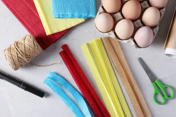 Decorăm ouă pentru Paști folosind hârtie colorată și pergament sub formă de iepuri. Tăiați benzi pentru urechile iepurilor din hârtie colorată. Pasul 2 . — Fotografie, imagine de stoc