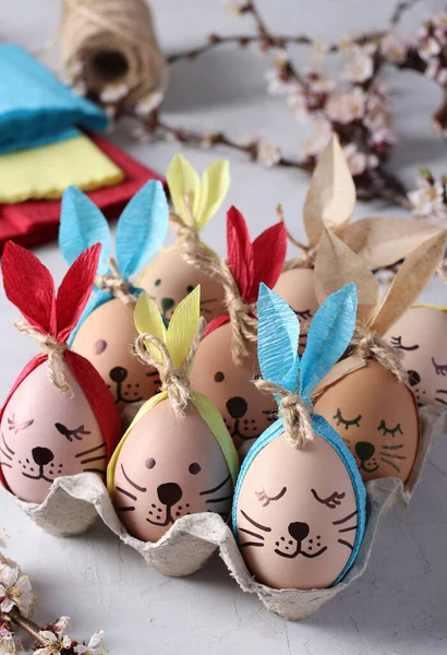 Conejitos de Pascua hechos de huevos con orejas multicolores hechas de papel o servilletas de colores. Idea para decorar huevos de Pascua. — Foto de Stock