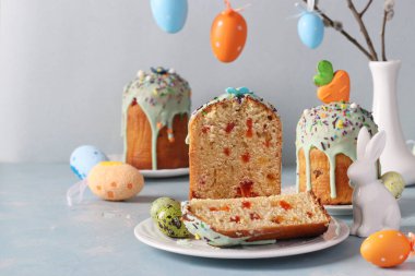 Pastel mavi arka planda renkli yumurtalarla kesilmiş Paskalya pastası. Bahar kilisesi tatil konsepti