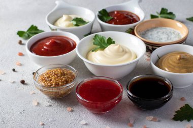 Sos takımı - ketçap, mayonez, hardal, soya sosu, barbekü sosu, tartar, hardal tohumu, kızılcık sosu ve açık gri arkaplanda dereotlu ekşi krema.