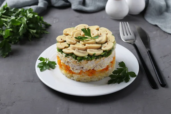 Salată de puf cu pui, ciuperci murate, cartofi și morcovi pe placă pe fundal gri . — Fotografie, imagine de stoc