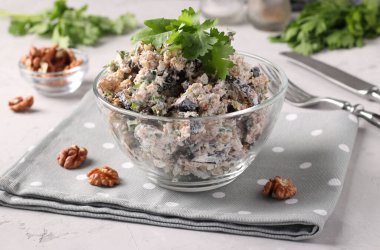 Açık gri arka planda şeffaf bir kasede patlıcanlı ve cevizli Gürcü salatası. Gürcistan mutfağının geleneksel aperatifi