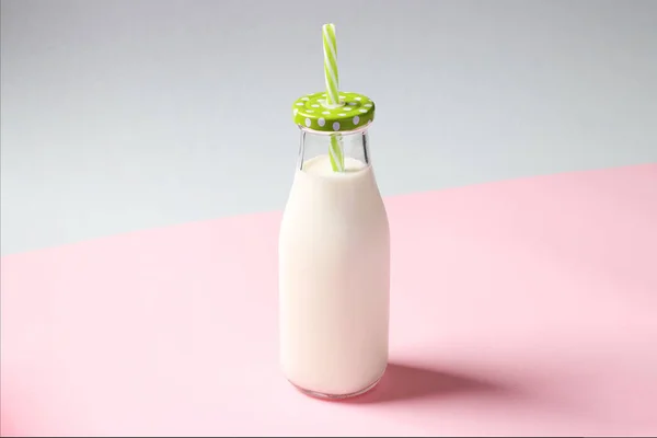 Botella de leche sobre fondo creativo rosa y azul. Formato horizontal — Foto de Stock