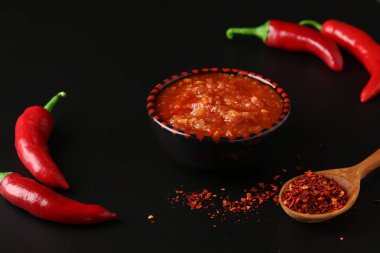 Acı sos ezmesi harissa, siyah arka planda kırmızı biber, Tunus ve Arap mutfağı.