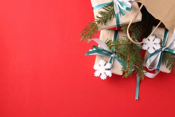 圣诞纸袋 装有彩带和雪片红色表面的牛皮纸礼物 圣诞节购物的概念 许愿的空间 度假卡从上面看 — 图库照片