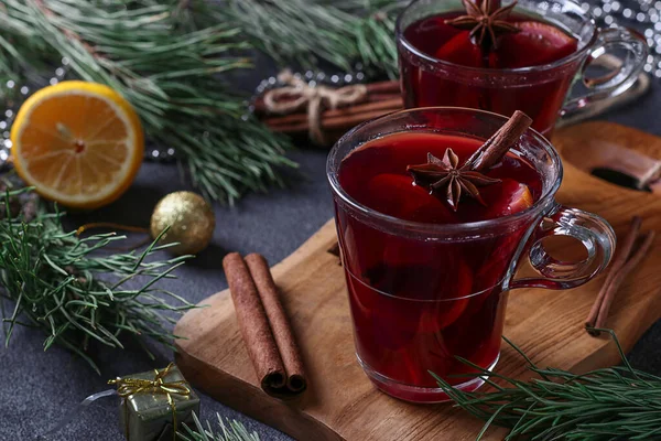 크리스마스에 마시는 와인 두 잔이 뒤섞인 어두운 배경에 나무 도마 위에 놓여 있다. — 스톡 사진
