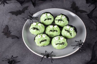 Green khinkali in form of Frankensteins on gray plate for Halloween party