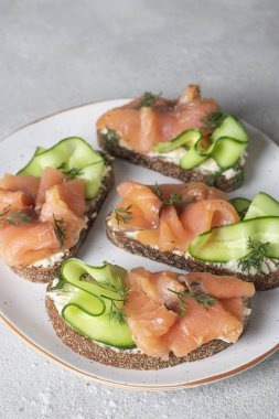 Homemade sandwiches with salted salmon, cream cheese and cucumber