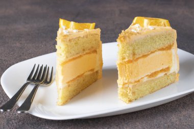 İki parça vanilyalı kek, turuncu kremalı ve kremalı.