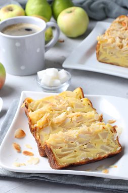 Armut ve elmalı turta parçaları, gri arka planda bir fincan kahve.