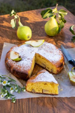 Kahverengi arka planda kesilmiş armutlu ev yapımı turta