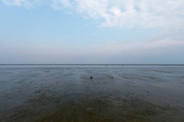 Alacakaranlıkta uzak bir yerden boş okyanus manzarası, karanlık sahilde tek başına dolaşmak.