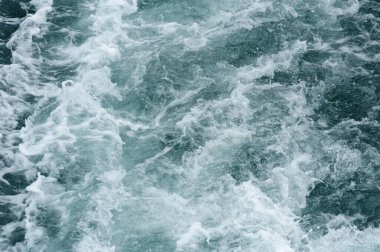 Güneş ışığındaki okyanus dalgası yüzey kağıdına yakın plan.