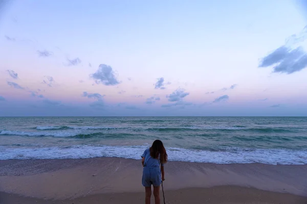 Uma menina vagando na praia ai crepúsculo — Fotografia de Stock