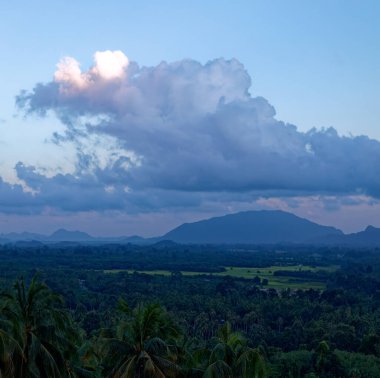 Tayland 'da güneşin doğuşunda tropikal dağın üzerinde tüylü, sakin bir bulut.