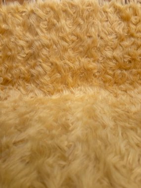 Altın hayvan yünü dokusu. Ürün arkaplanı için pofuduk kürk halının yakın çekim dokusu, düz görüş
