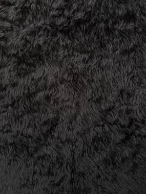 Siyah hayvan yünü dokusu. Ürün arkaplanı için pofuduk kürk halının yakın çekim dokusu, düz görüş
