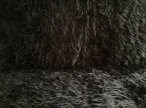Zwarte dierlijke wol textuur achtergrond. Close-up textuur van pluche pluizig bont tapijt voor product achtergrond, 30 graden hoek uitzicht — Stockfoto