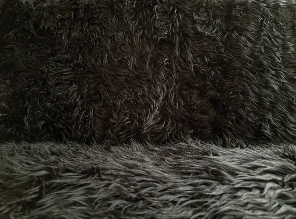 Zwarte dierlijke wol textuur achtergrond. Close-up textuur van pluche pluizig bont tapijt voor product achtergrond, recht zicht — Stockfoto