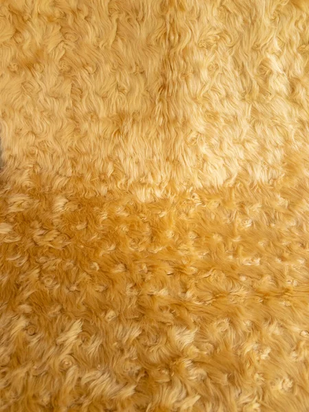 Gouden dierlijke wol textuur achtergrond. Close-up textuur van pluche pluizig bont tapijt voor product achtergrond 45 hoek uitzicht — Stockfoto