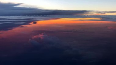 Gökyüzünün üstündeki renkli bulutlar uçaktan görünüyor.