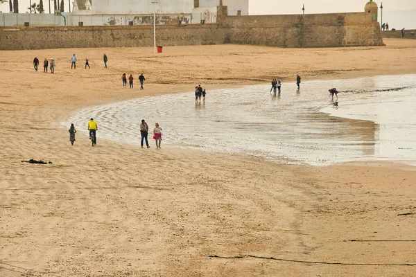Cadiz, İspanya, 20 Şubat 2020: Atlantik Denizi 'nin soğuk sahillerinde insanların kış yürüyüşleri. İnsanlar sahilde soğuk mevsimde rahatlar.