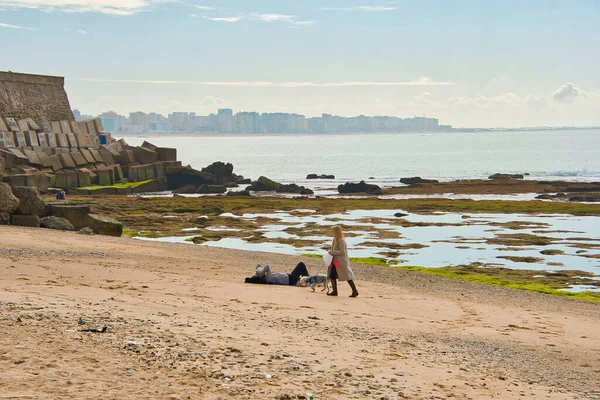 Cadiz, İspanya, 20 Şubat 2020: Atlantik Denizi 'nin soğuk sahillerinde insanların kış yürüyüşleri. İnsanlar sahilde soğuk mevsimde rahatlar.