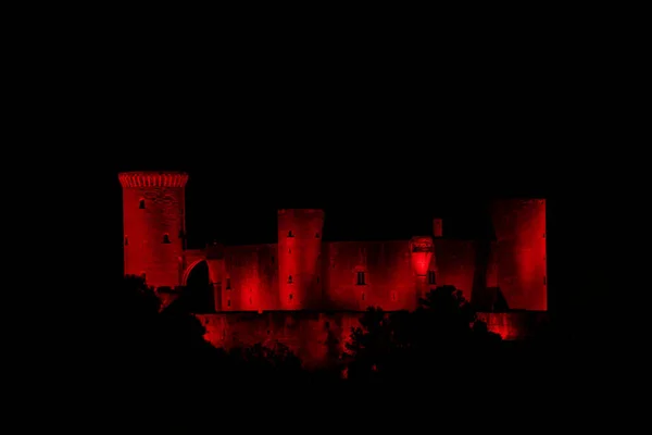 PALMA de MALLORCA, MAJORCA (ISLAS BalEARES), İspanya - 1 Aralık 2020: Bellver Şatosu (Castell de Bellver) Dünya AIDS Günü için kırmızıya boyanmış, Palma şehir merkezinin 3 km batısındaki bir tepede Gotik tarzı bir kaledir.