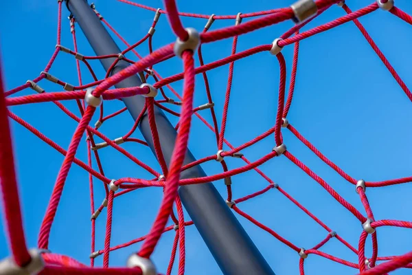 Red ropes on playground against the blue sky