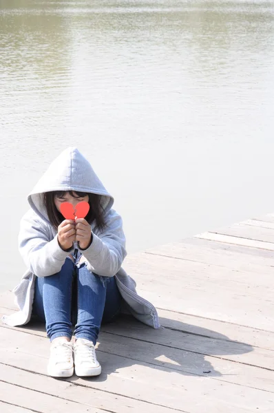 Menina triste orando para se reconciliar com o coração partido vermelho — Fotografia de Stock