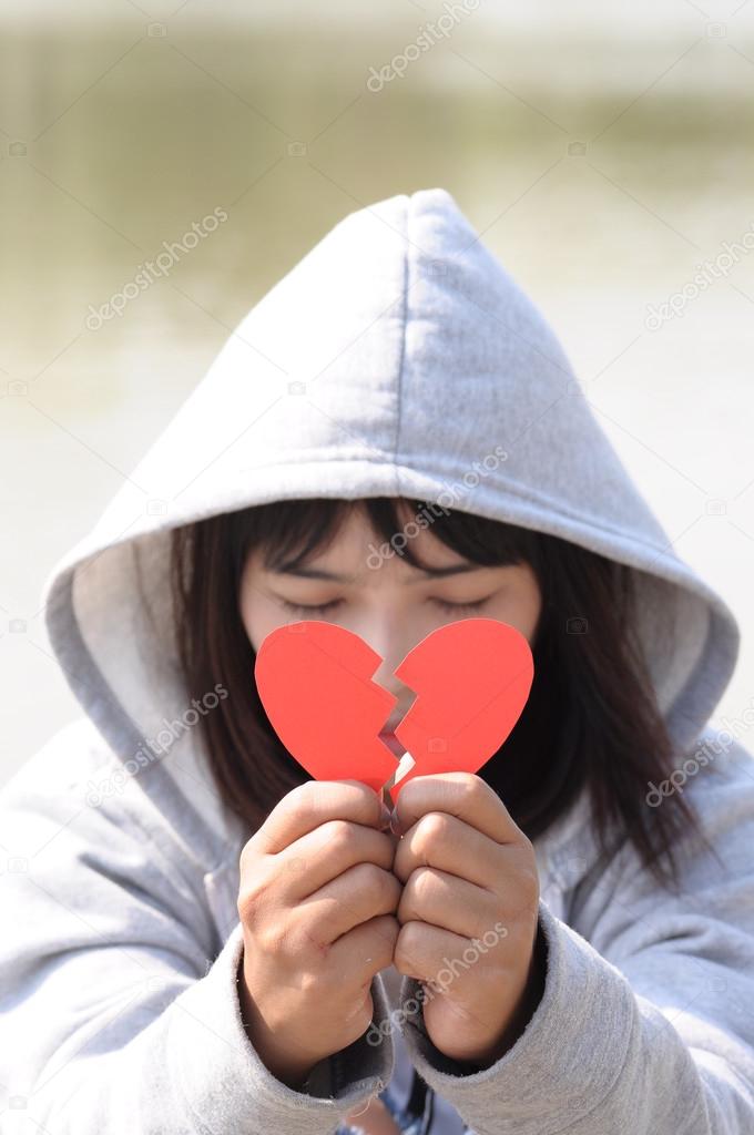 Sad Girl Praying To Reconcile With Red Broken Heart Shape Stock
