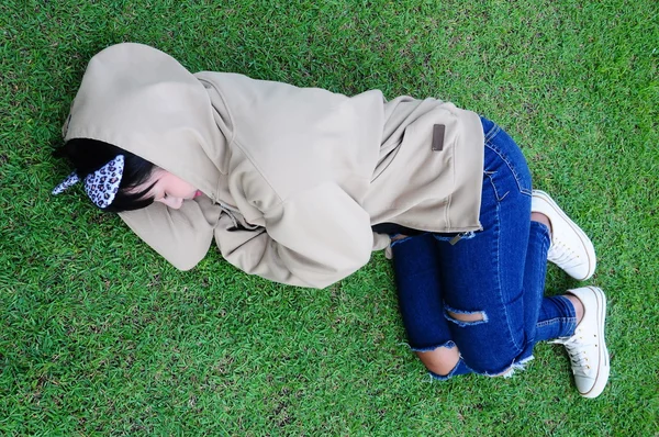 Menina bonito dormir na grama no jardim — Fotografia de Stock