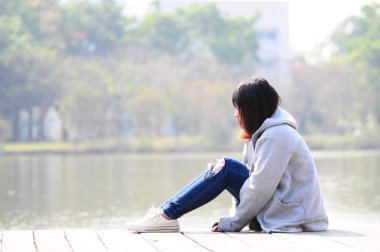 Nehir yakınında oturan depresif kadın