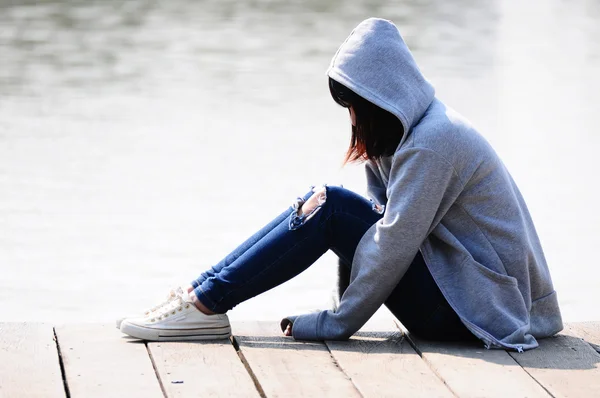 Młoda kobieta w rozpacz siedzący w pobliżu rzeki — Zdjęcie stockowe