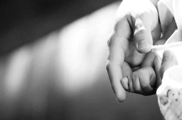 Adult hand gently holding adult baby finger — Stock Photo, Image