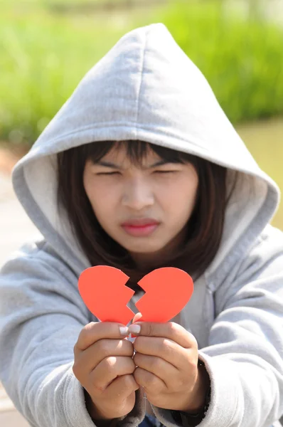 Young girl holding broken paper red valentine heart — Stock Photo, Image