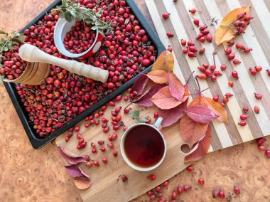 Bir tepside sulu gül kalçası hasat ve yakın plan gül kalçası çayı..