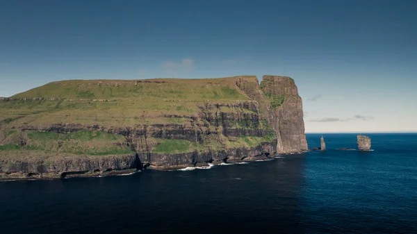 日光浴 蓝色海洋和绿色悬崖峭壁在法罗群岛形成的岩石群 — 图库照片