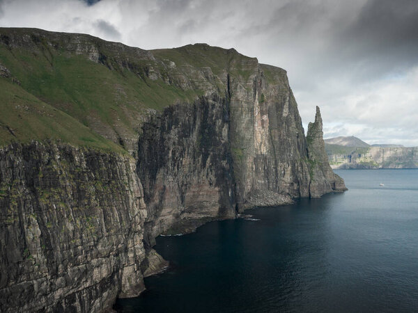 Rock formation Trollkonufingur with steep cliffs on Vagar Island, Faroe Islands