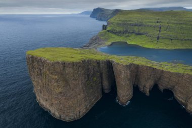 Vagar Adası 'ndaki sarp kayalıklar, Leitisvatn Gölü ve yukarıdaki Faroe Adaları kıyı şeridi.
