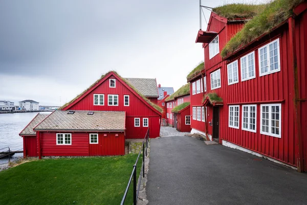 Torshavn, Faroe Adaları 'ndaki Tinganes hükümet bölgesindeki kırmızı binalardan geçerek.