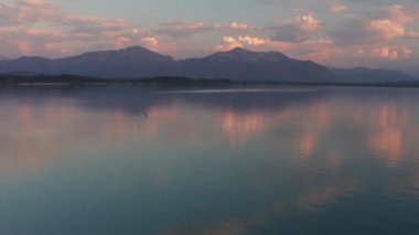 Bavyera 'daki Chiemsee Gölü' nde Alp Dağları 'nda gün batımında yaz boyunca kürek çekerek ayakta dururlar.