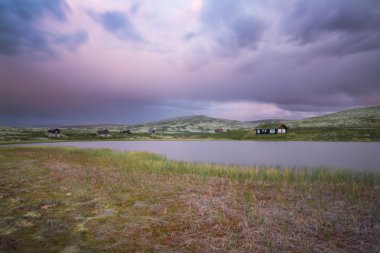 Kulübe göl günbatımı sırasında Norveç'in peyzaj üzerinde