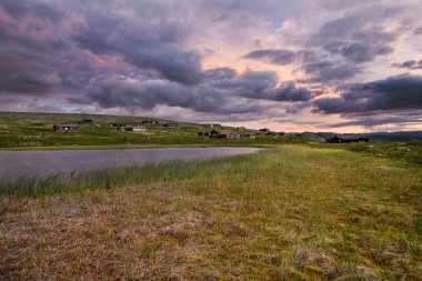 Kulübe göl günbatımı sırasında Norveç'in peyzaj üzerinde