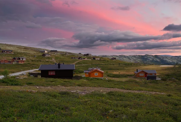 Gün batımı sırasında Norveç'in manzara kulübeleri