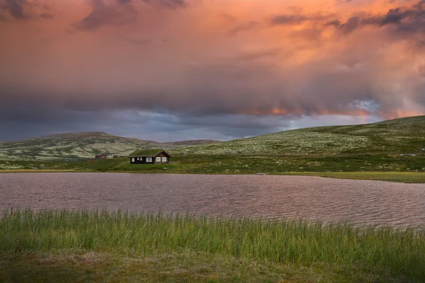 日没時にノルウェーの風景で湖の上の小屋 — ストック写真