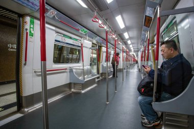 01-22-2015 Hong Kong, Çin. Hong Kong metro vagonu ve insanlar. Metro istasyonundaki adam izliyor..