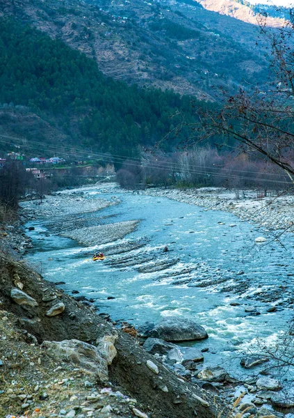 Rafting : boat moving on quiet  river section-river Beas . next to Kullu town in Himachal Pradesh.  Really service man control boat himself , other tourists for pay and making selfie. unrecognizable persons.